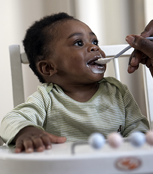 Bebê sendo alimentado em um cadeirão.